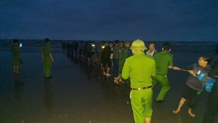 Lực lượng chức năng cùng người dân trục vớt chiếc thuyền lên bờ (Ảnh Lộc Hà 24h)