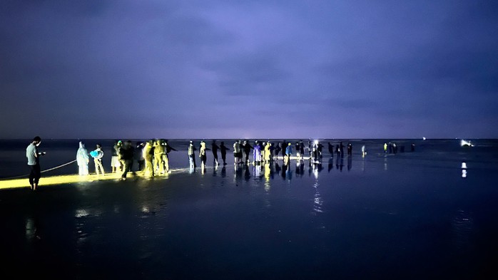 Lực lượng chức năng cùng người dân tiến hành trục vớt chiếc tàu của ông H. (Ảnh Công an xã Lộc Hà)