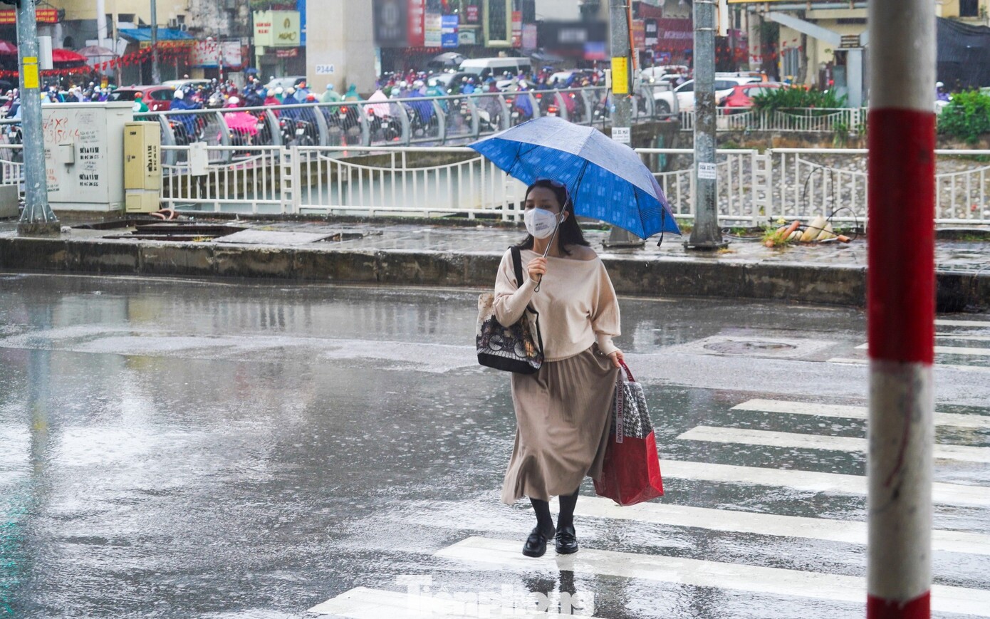 Trong không khí se lạnh và mưa phùn lất phất, dòng người vội vã trên phố, tay cầm ô len lỏi giữa những con đường ướt át.