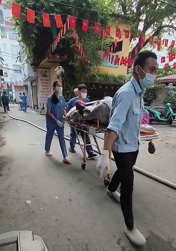 Thi thể được bọc kín bằng chăn đưa ra ngoài. Ảnh: Trần Quyết Thắng