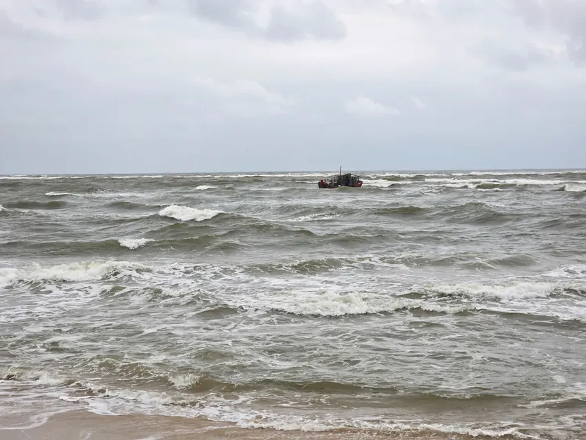 Tàu cá hiện vẫn nằm ngay cửa biển, chưa thể lai dắt vào bờ. Ảnh: MINH TRƯỜNG