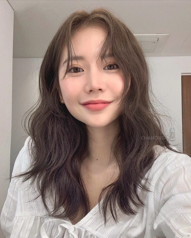 Tóc xoăn sóng lơi là kiểu tóc “chân ái” của mọi cô gái yêu sự dịu dàng. Những lọn tóc uốn nhẹ rơi tự nhiên giúp gương mặt thêm mềm mại, thanh thoát. Khi kết hợp cùng váy hoa nhí, váy voan hay váy trắng, nàng sẽ trông vừa trẻ trung vừa sang chảnh đúng chuẩn tiểu thư.