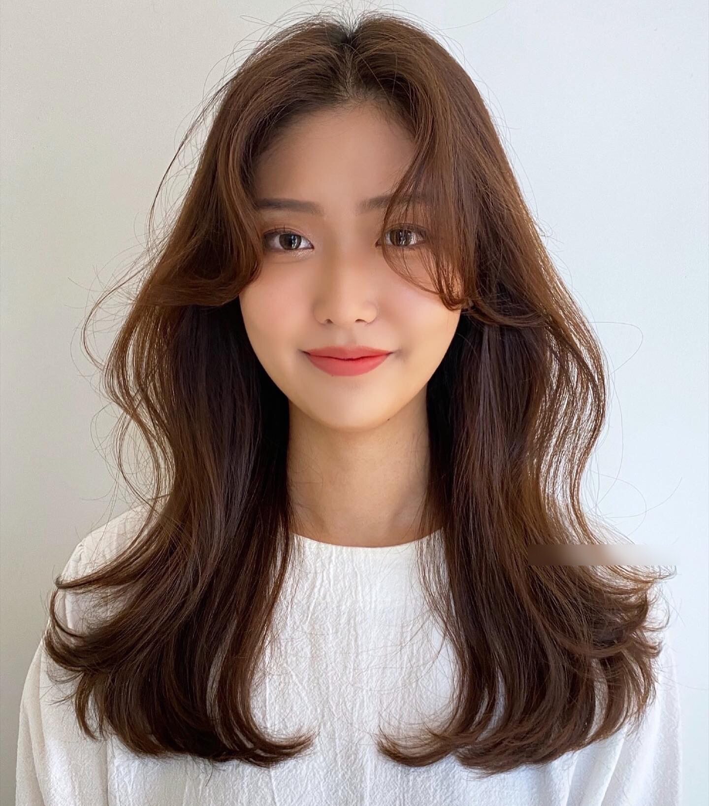 Kiểu mái uốn cong nhẹ theo hình chữ S ôm sát gò má, giúp che bớt phần má tròn và tạo đường cong mềm mại cho gương mặt. Đây là “vũ khí” hack V-line được idol Hàn ưa chuộng, vừa giúp mặt thon gọn vừa mang lại vẻ nữ tính, sang chảnh tự nhiên.