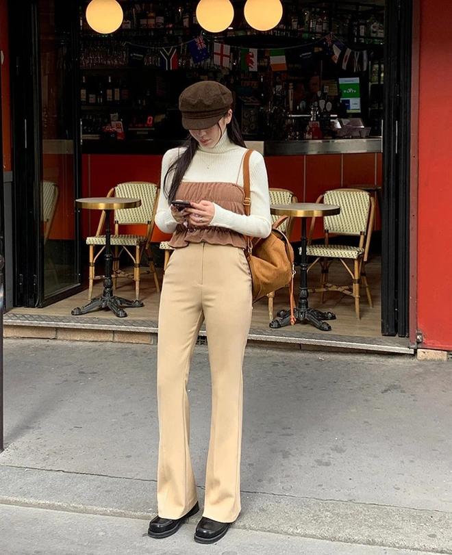 Công thức “tối giản mà sang” được hội công sở yêu thích. Quần be cạp cao phối áo len ôm hoặc cổ lọ giúp tôn dáng, tạo vẻ thanh lịch, ấm áp. Chỉ cần thêm blazer dáng rộng và đôi boot cổ ngắn, bạn đã có ngay outfit chuẩn quý cô châu Âu.