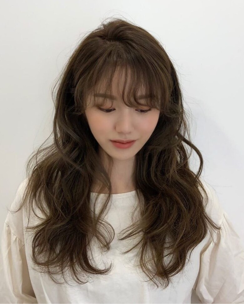 Những lọn sóng lớn, mềm mại giúp mái tóc dài trông bồng bềnh, nữ tính mà không quá cầu kỳ. Khi kết hợp cùng váy liền hoặc áo blouse, kiểu tóc này càng tôn lên vẻ dịu dàng, cuốn hút.