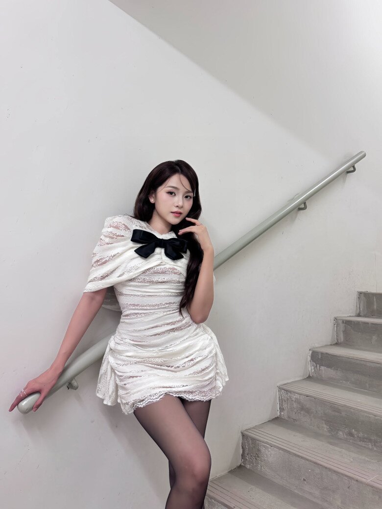Lần khác, Lê Tam Triều Dâng hóa tiểu thư kiêu kỳ trong thiết kế đầm ren ngắn xếp nhún, tạo điểm nhấn tương phản bằng chiếc nơ nhung đen nổi bật cùng quần tất mỏng quyến rũ.